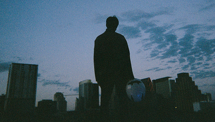 Cover for the Skeletons extended play showing a man facing a city.